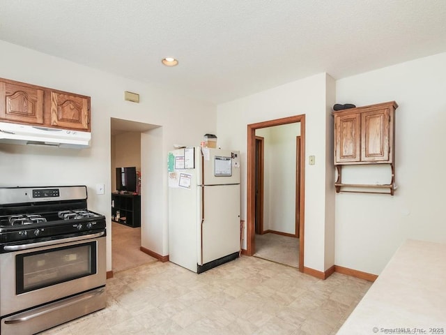 17-19 Fenwick St, Hartford, CT 06114 - kitchen featuring freestanding refrigerator, stainless steel gas range, under cabinet range hood, light countertops, and brown cabinets
