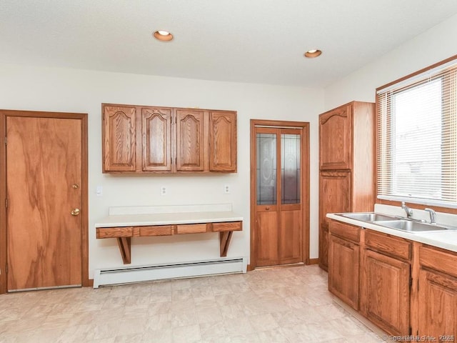 17-19 Fenwick St, Hartford, CT 06114 - kitchen with a baseboard heating unit, brown cabinetry, a sink, and light countertops