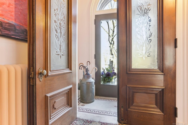 entrance foyer with radiator heating unit and a wealth of natural light
