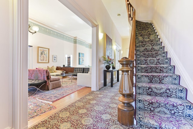 staircase with baseboards and wood finished floors