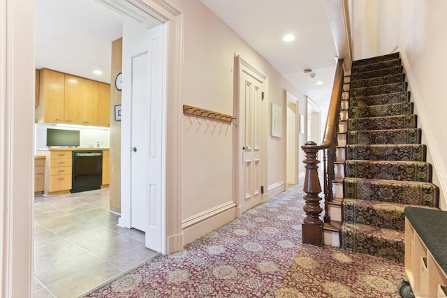 hall with light tile patterned flooring, baseboards, stairway, and recessed lighting