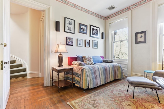 bedroom featuring hardwood / wood-style flooring, baseboards, and visible vents