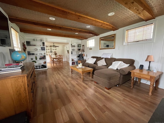 living room featuring wood finished floors, recessed lighting, and beamed ceiling