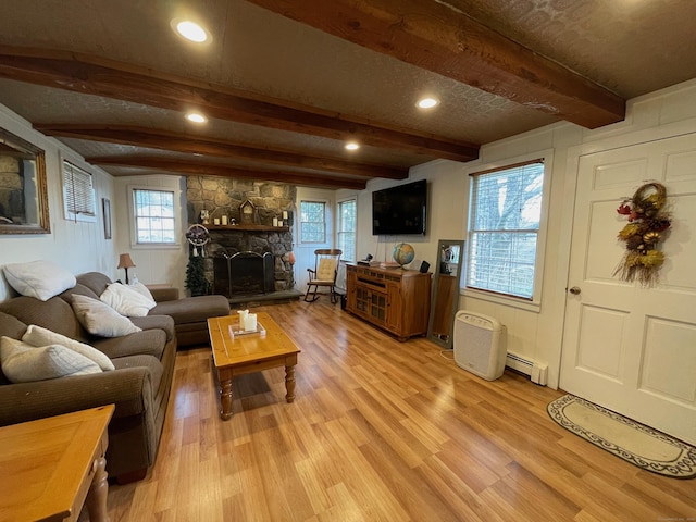 living area featuring a baseboard heating unit, beam ceiling, and light wood-type flooring