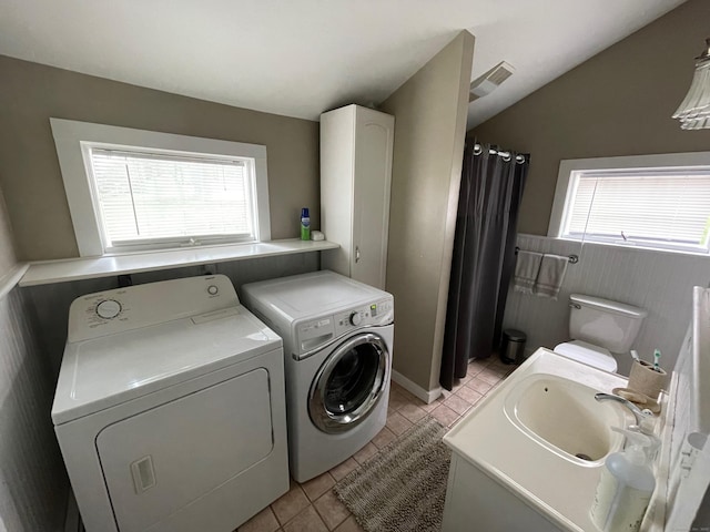 clothes washing area with plenty of natural light, visible vents, laundry area, and washer and clothes dryer