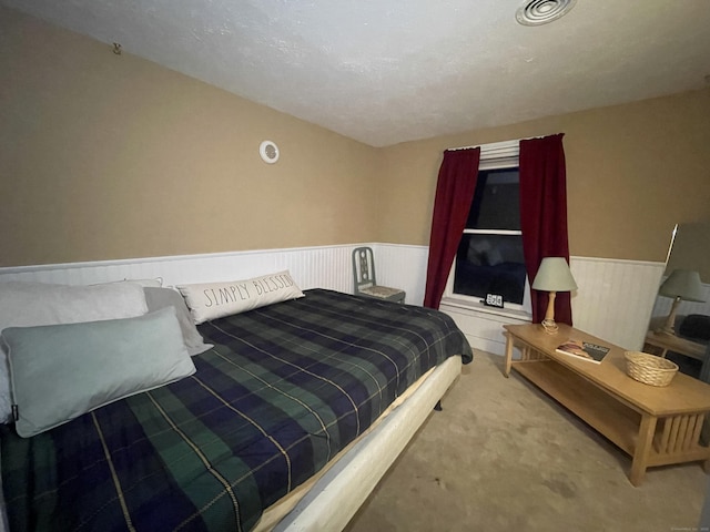 carpeted bedroom featuring visible vents and wainscoting