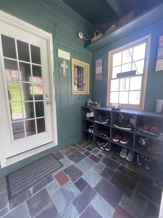 mudroom featuring stone tile floors and beam ceiling