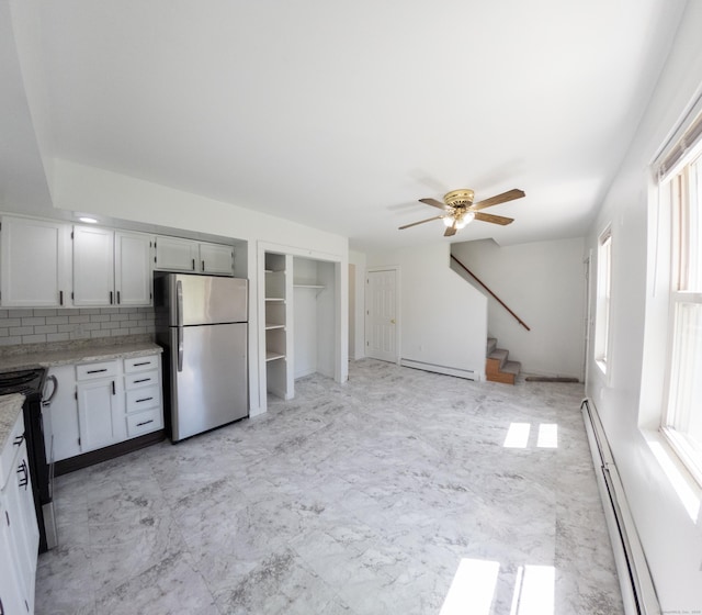 interior space with baseboard heating, stove, light countertops, freestanding refrigerator, and a baseboard heating unit