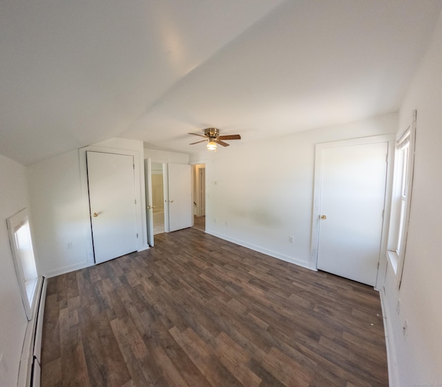 bonus room with a ceiling fan, baseboards, a baseboard heating unit, and dark wood-style floors