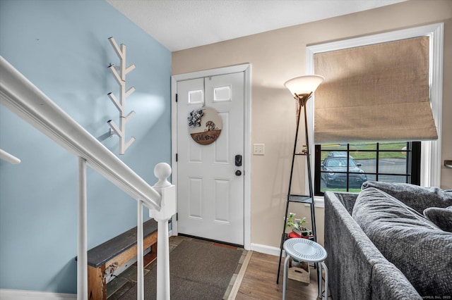 entrance foyer with baseboards and wood finished floors
