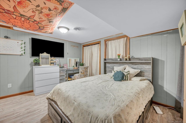 bedroom with visible vents, baseboards, and wood finished floors