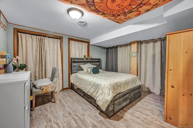 bedroom with light wood finished floors and visible vents