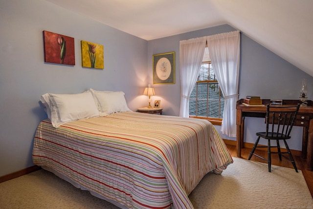 bedroom with baseboards, wood finished floors, and lofted ceiling