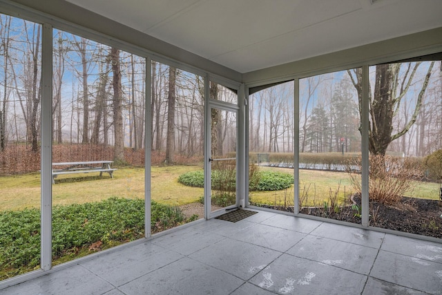unfurnished sunroom featuring a water view