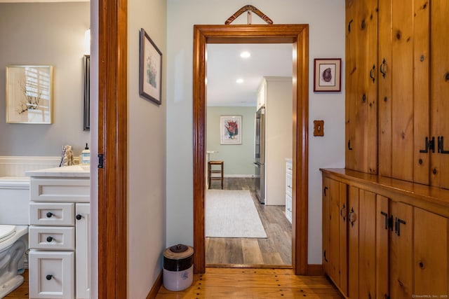 hallway featuring light wood-style flooring and recessed lighting