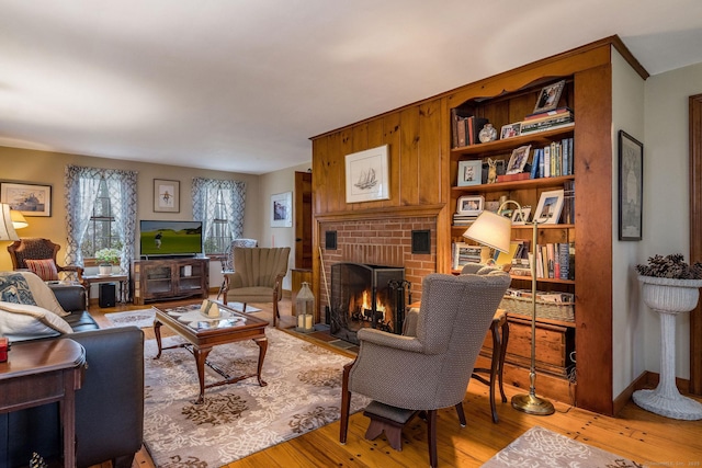living room with light wood-type flooring and a brick fireplace