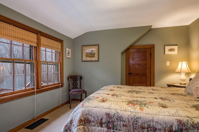carpeted bedroom with baseboards, vaulted ceiling, and visible vents