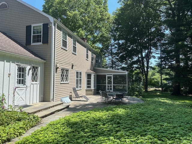 125 Silver Spring Rd, Fairfield, CT 06824 - back of property with a sunroom, a patio area, a yard, and a chimney