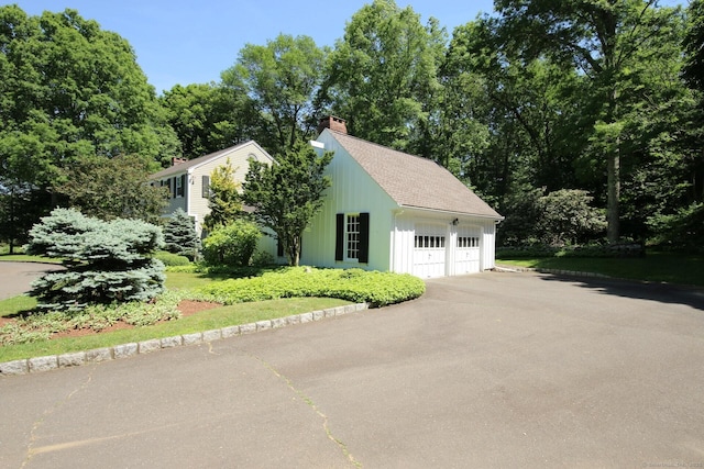 125 Silver Spring Rd, Fairfield, CT 06824 - view of side of property with a chimney, a garage, and board and batten siding