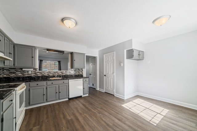 kitchen with baseboards, gray cabinets, white appliances, backsplash, and dark wood finished floors
