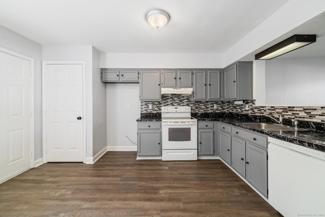 kitchen with a sink, gray cabinets, white appliances, and dark wood-style floors