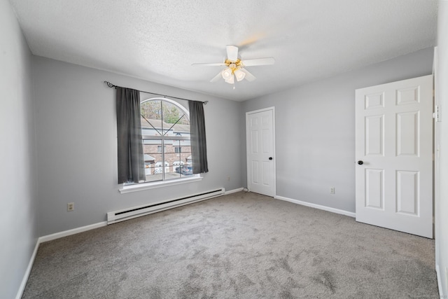 unfurnished bedroom with baseboards, a ceiling fan, a textured ceiling, baseboard heating, and carpet floors