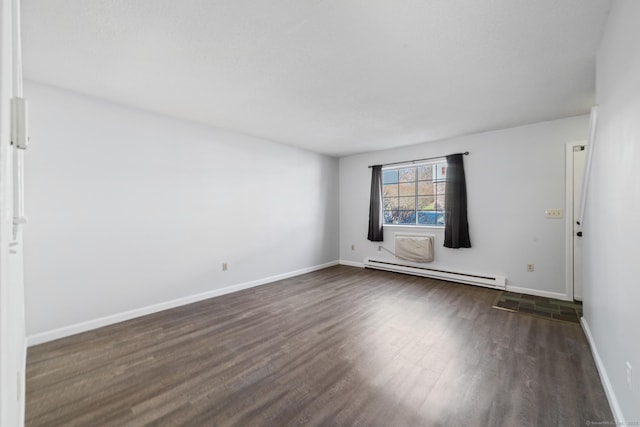 empty room with baseboard heating, dark wood-type flooring, and baseboards