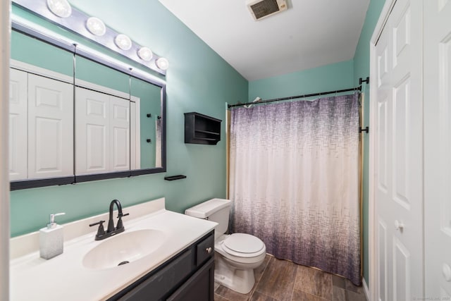 full bathroom featuring vanity, a shower with curtain, toilet, visible vents, and wood finished floors