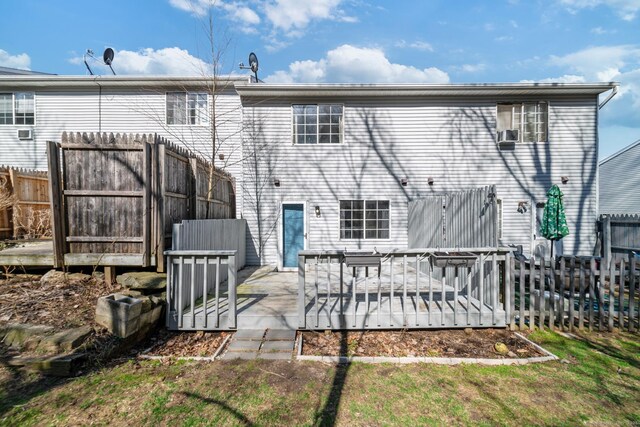 rear view of property featuring fence and a deck