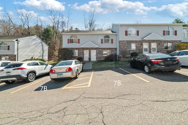 multi unit property featuring uncovered parking and brick siding