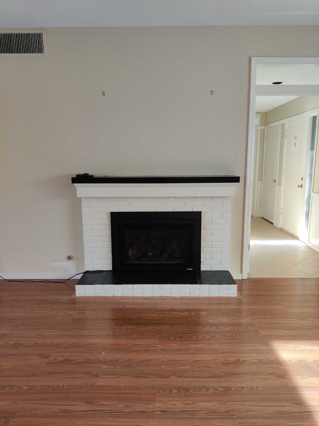 room details featuring visible vents, wood finished floors, and a fireplace
