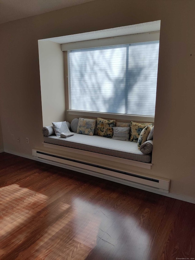 living room with wood finished floors and a baseboard heating unit