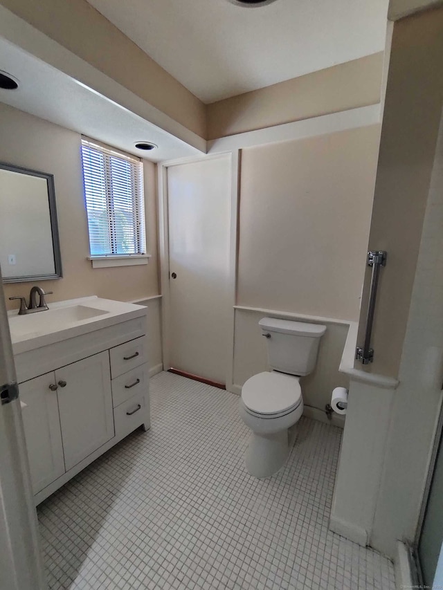 bathroom featuring toilet, vanity, and tile patterned floors