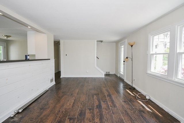 unfurnished living room with visible vents, baseboards, and wood finished floors