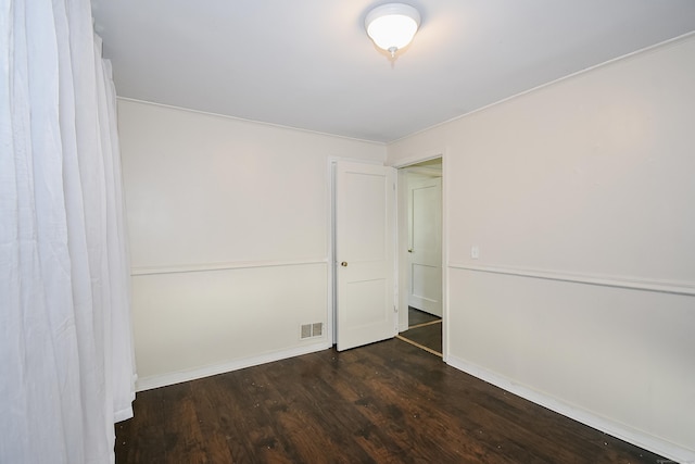 unfurnished bedroom with dark wood-style flooring, baseboards, and a closet
