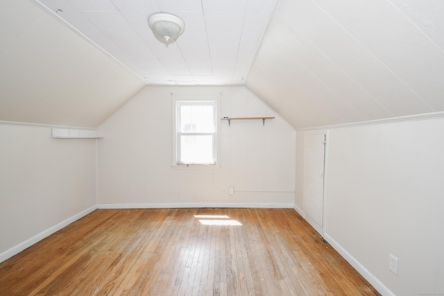 additional living space with wood-type flooring, baseboards, and vaulted ceiling