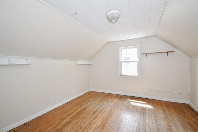 bonus room featuring baseboards, lofted ceiling, and hardwood / wood-style flooring