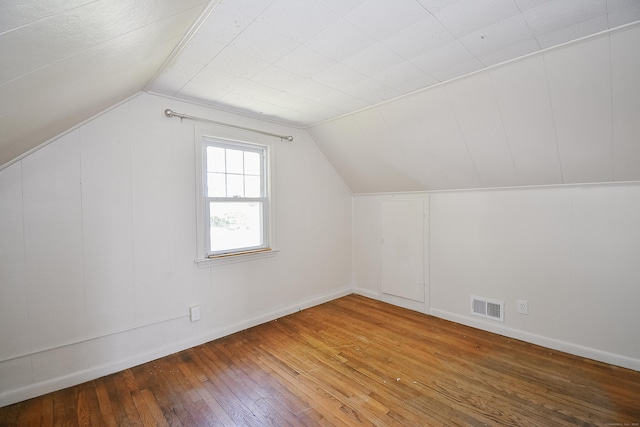 bonus room featuring wood-type flooring, baseboards, visible vents, and vaulted ceiling