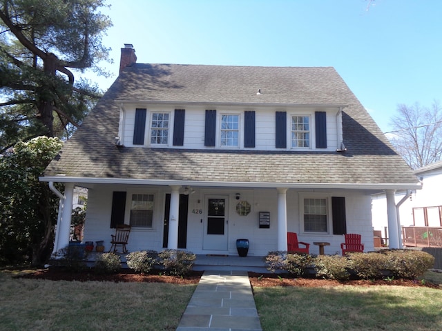 426 Courtland Ave Apt 1, Stamford, CT 06906 - view of front of house featuring covered porch, a chimney, a front yard, and a shingled roof