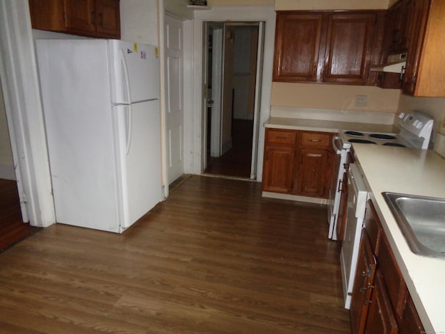426 Courtland Ave Apt 1, Stamford, CT 06906 - kitchen featuring white appliances, light countertops, dark wood finished floors, under cabinet range hood, and a sink