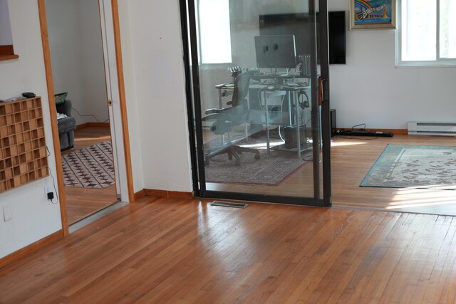 953 Rainbow Trl, Orange, CT 06477 - doorway to outside with baseboard heating, hardwood / wood-style flooring, and baseboards