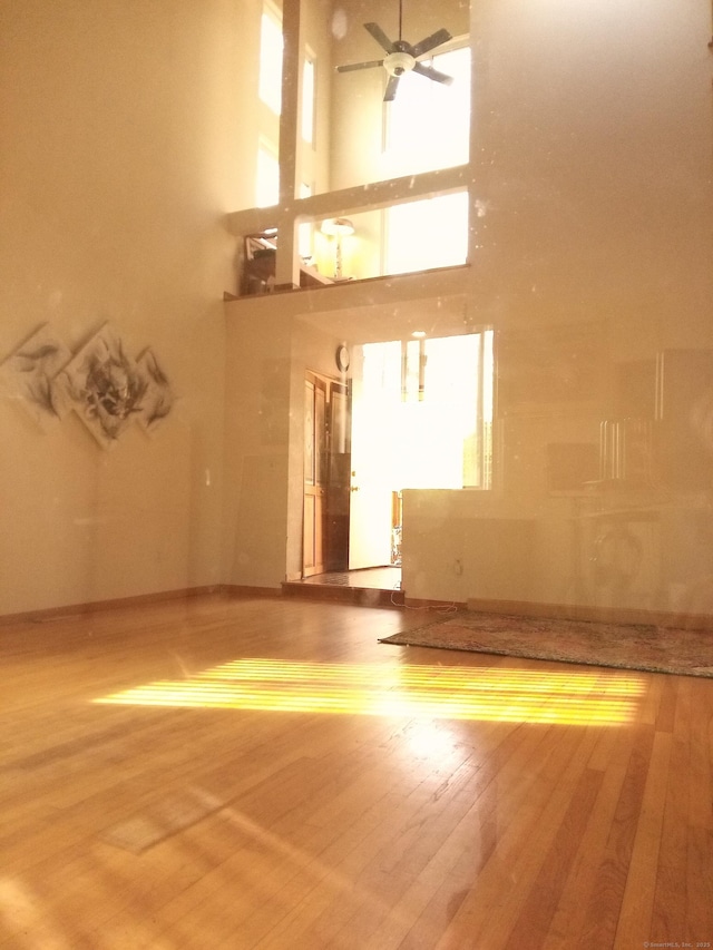 953 Rainbow Trl, Orange, CT 06477 - unfurnished living room with ceiling fan, wood finished floors, and a towering ceiling