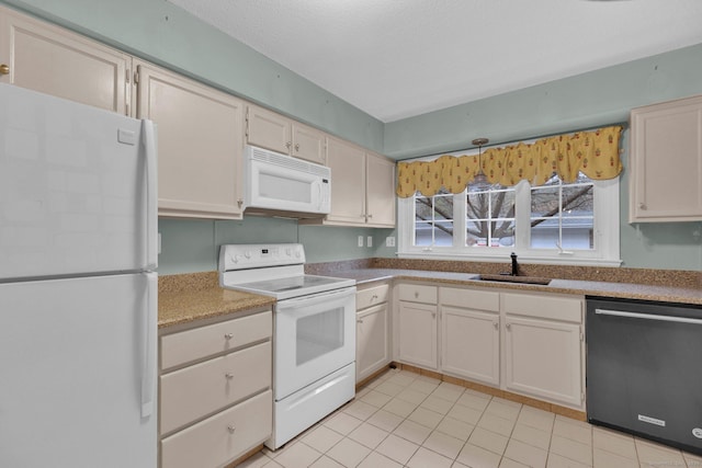 kitchen with a textured ceiling, light tile patterned flooring, a sink, and white appliances
