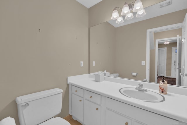 half bathroom with vanity, visible vents, and toilet
