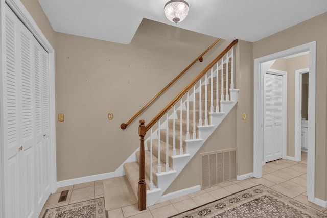 stairs featuring baseboards, tile patterned flooring, and visible vents