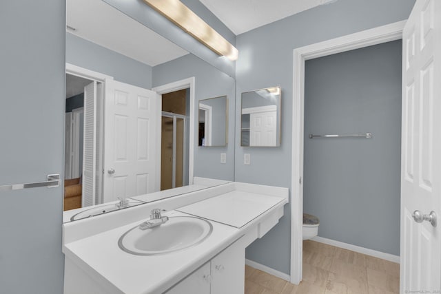 full bathroom featuring toilet, baseboards, and vanity