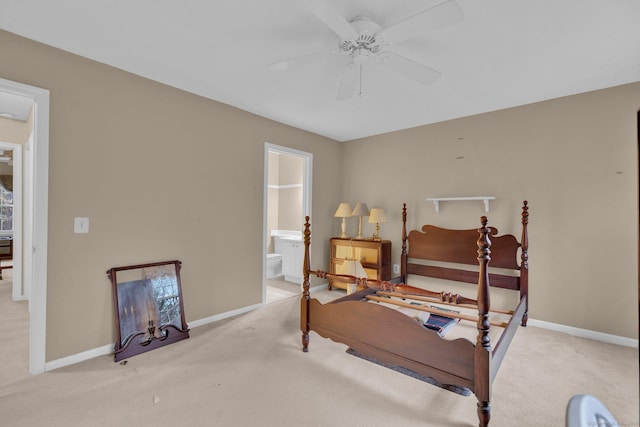 carpeted bedroom with baseboards, connected bathroom, and ceiling fan