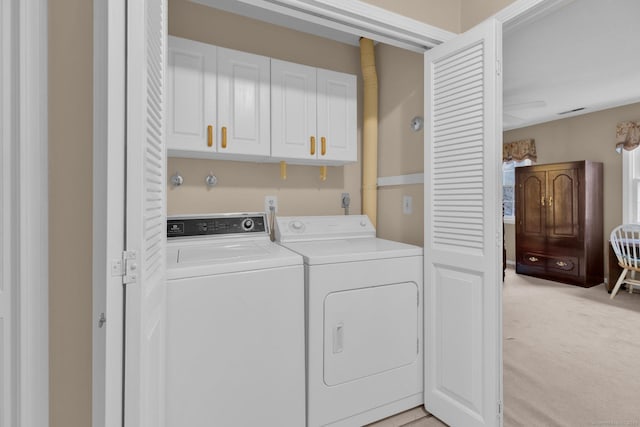 laundry area with light carpet, washing machine and dryer, and cabinet space