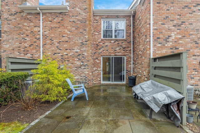 rear view of property with a patio area, brick siding, and cooling unit