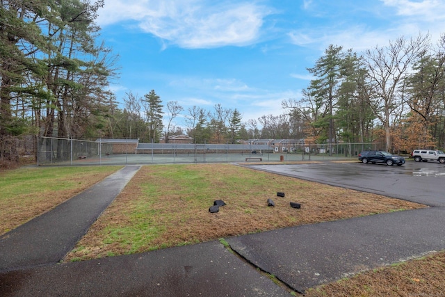 view of yard with a tennis court and fence